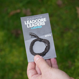 Carper leadcore leader setup shown with looped leaders package in hand on green grass background.
