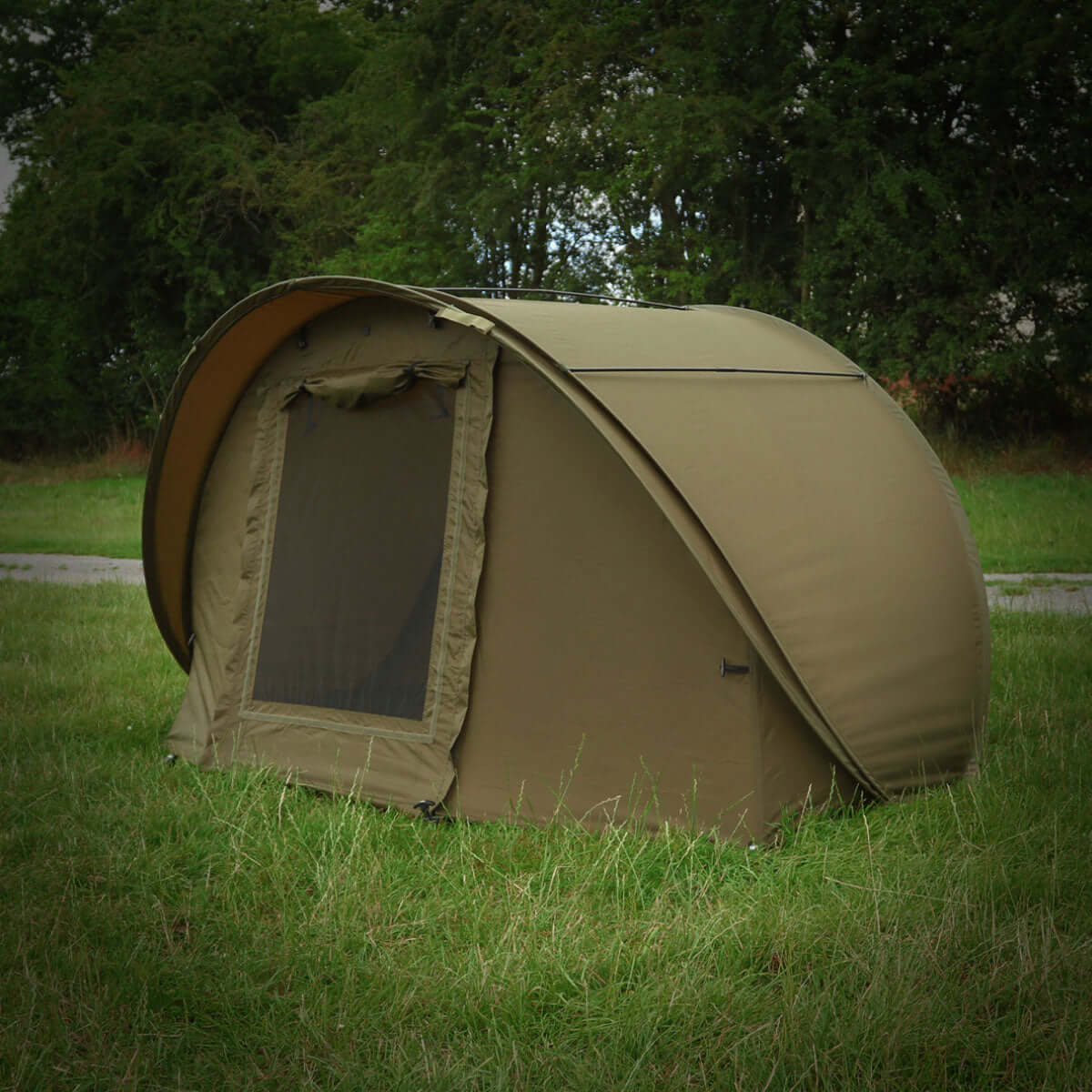 Speedflex Bivvy - Green in a grassy outdoor setting, showcasing its quick pop-up design and spacious structure.