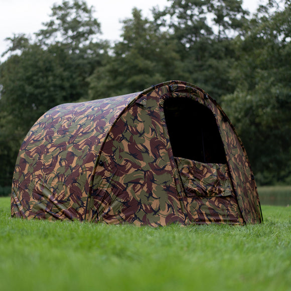 V2 Speedflex bivvy overwrap in DPM camouflage design set up outdoors on grassy landscape.